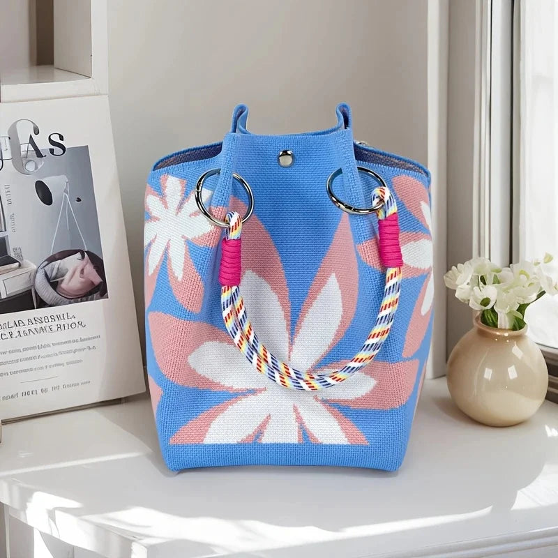 Blue tote bag with floral design on a white surface