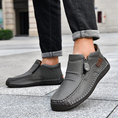 Gray loafers worn by a person on a pavement background