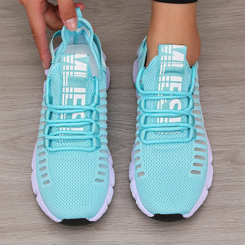 Turquoise running shoes with white soles on a wooden floor