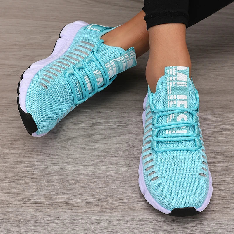 Turquoise running shoes with white soles on a wooden floor