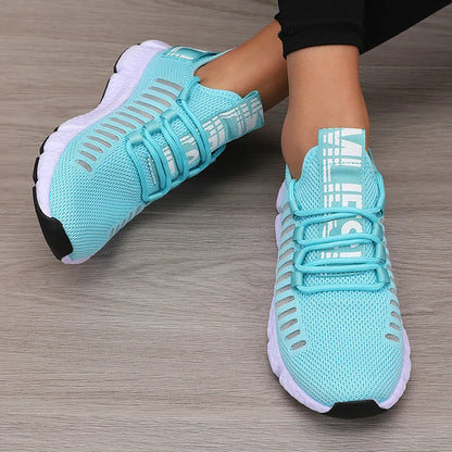 Turquoise running shoes with white soles on a wooden floor