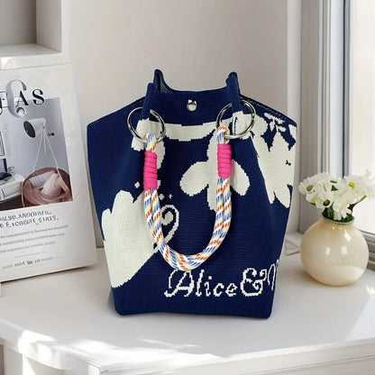 Navy blue tote bag with cloud design and colorful handles on a white surface.