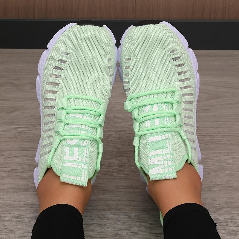 Light green running shoes worn on a wooden floor