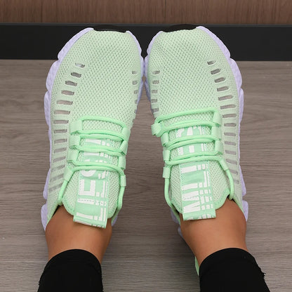 Light green running shoes worn on a wooden floor