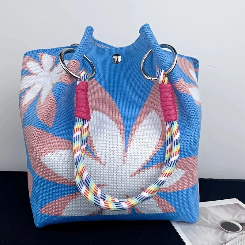 Blue bag with floral pattern and colorful handle on a white background