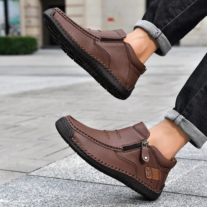 Brown leather shoes worn by a person on a pavement background