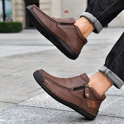 Brown leather shoes worn by a person on a pavement background