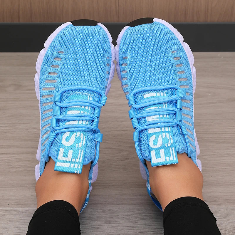 Blue athletic shoes with white soles on a wooden floor