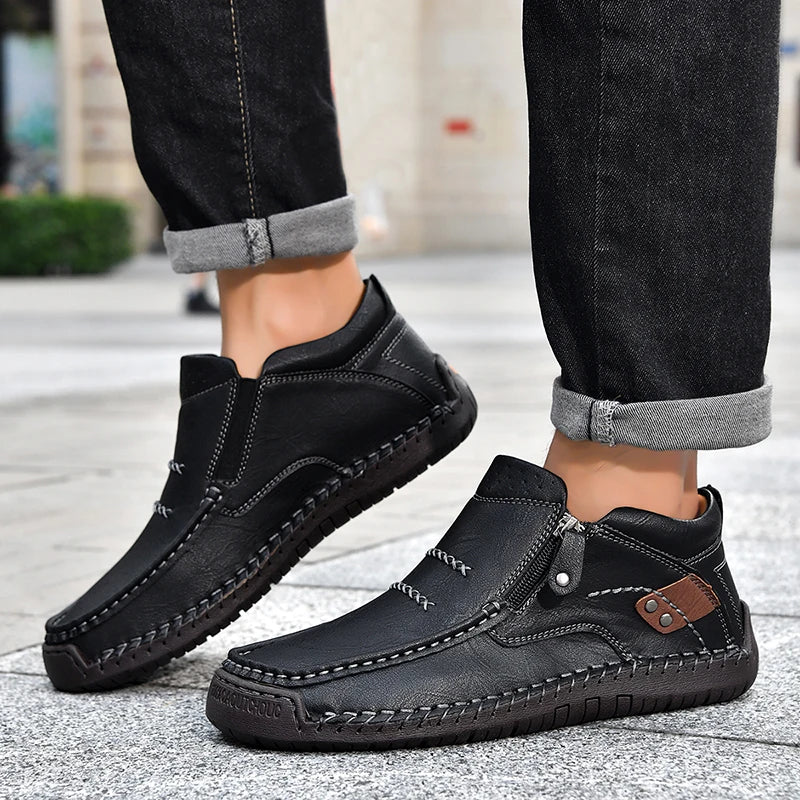 Black leather shoes worn with black jeans on a blurred outdoor background