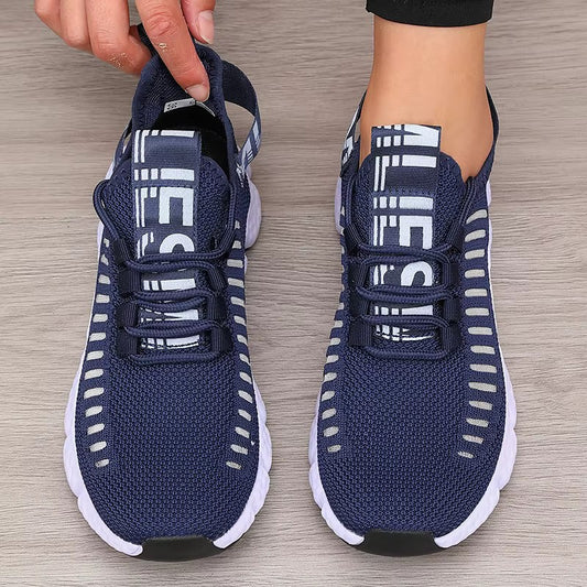 Navy blue athletic shoes with white accents on a wooden floor.